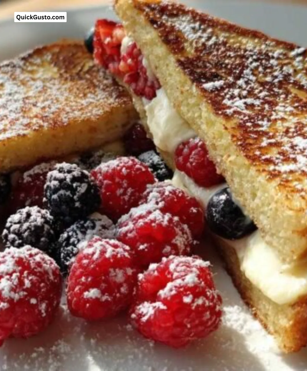 Delicious stuffed French toast on a plate topped with syrup and berries