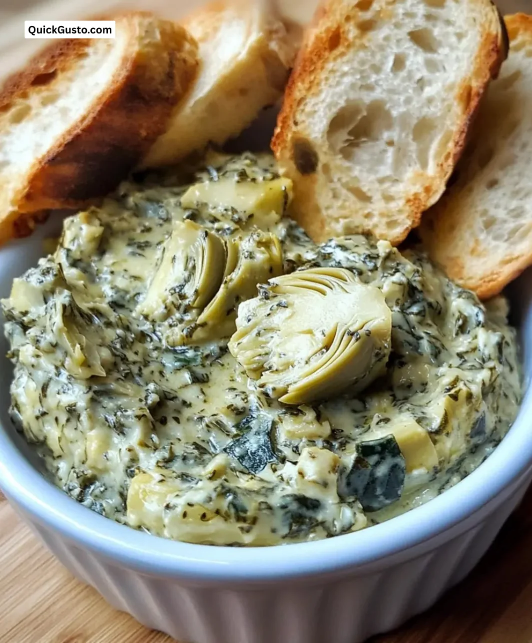 Delicious spinach artichoke spread served in a bowl with fresh ingredients.