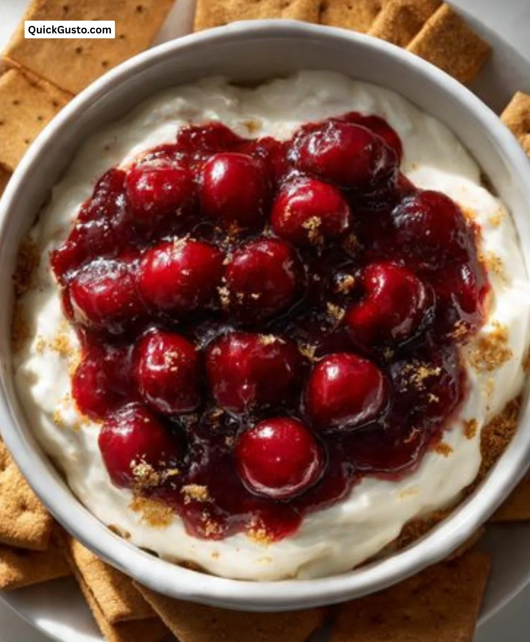 Delicious cherry cheesecake dip served in a bowl with a graham cracker garnish.