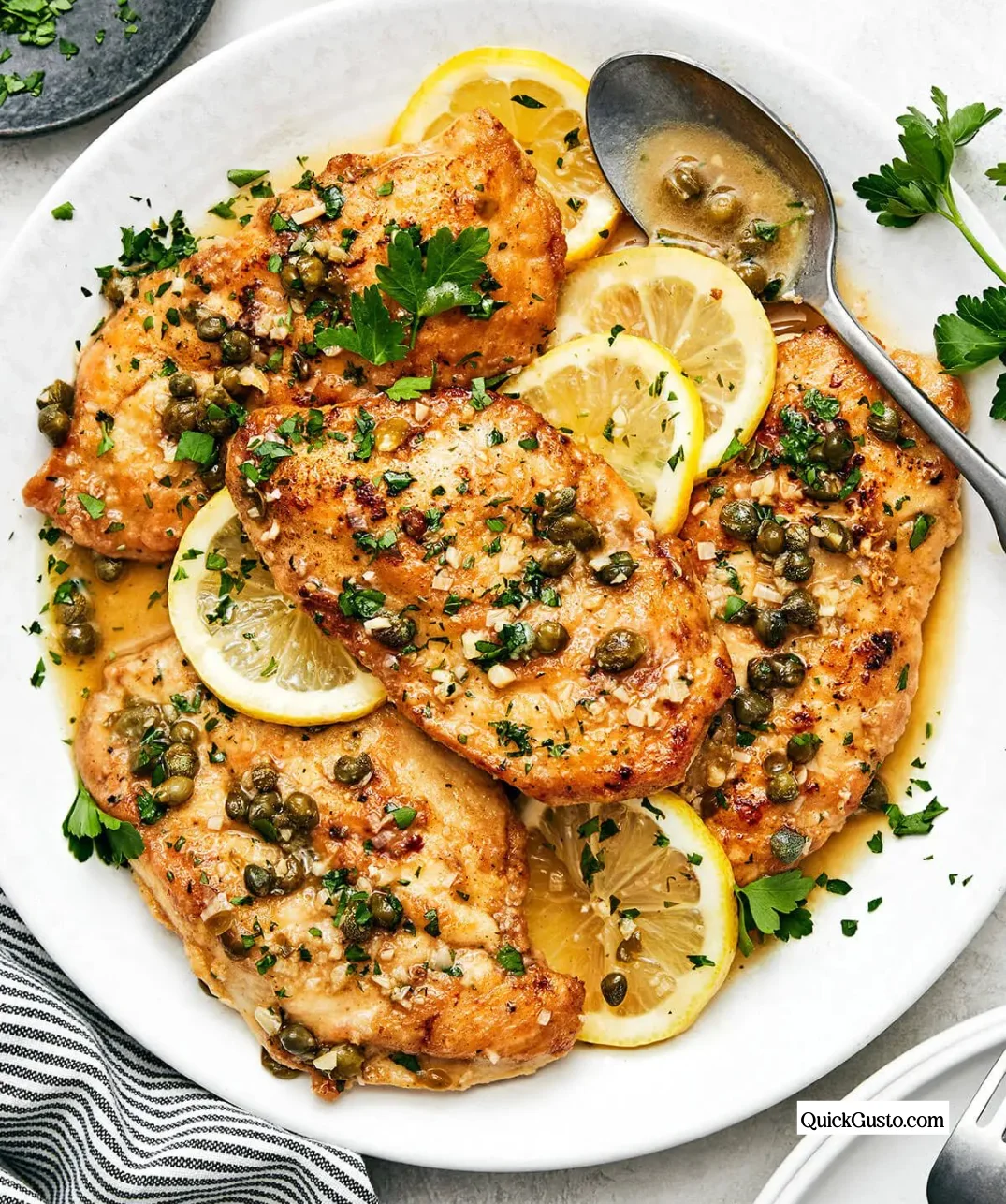 Delicious Chicken Piccata served with lemon and capers on a white plate