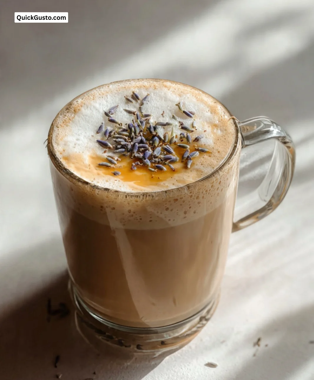 A creamy Honey Lavender Latte topped with lavender sprigs and honey drizzles.