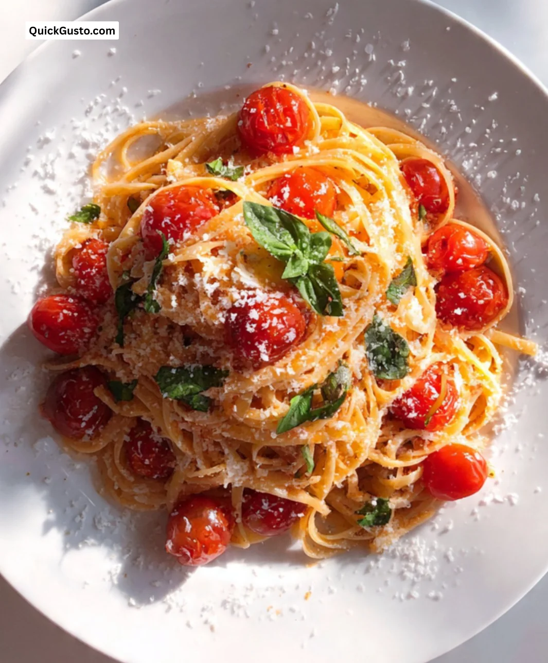 Plate of linguine with cherry tomato sauce garnished with basil