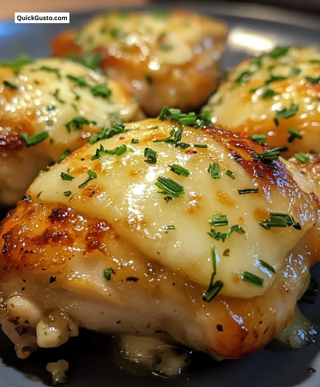 Melt-in-your-mouth garlic cheese baked chicken thighs garnished with herbs