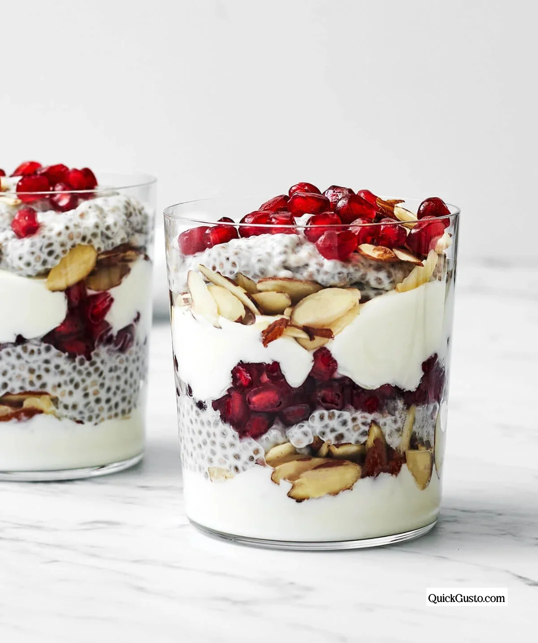 A colorful pomegranate chia pudding parfait layered in a glass.