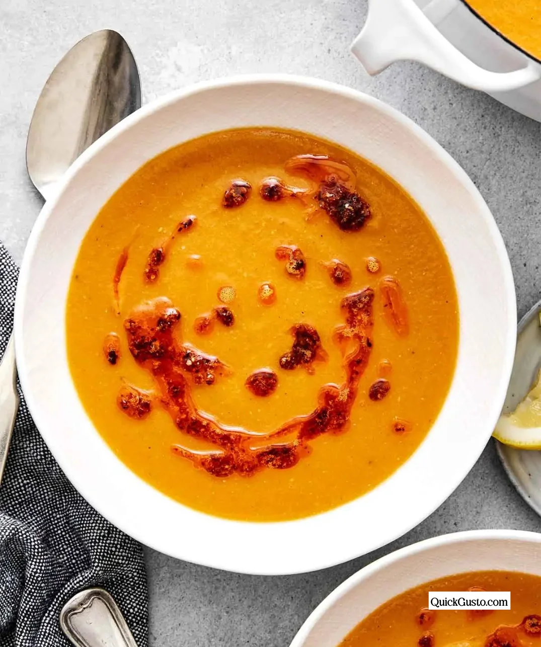 Bowl of homemade red lentil soup topped with herbs and spices