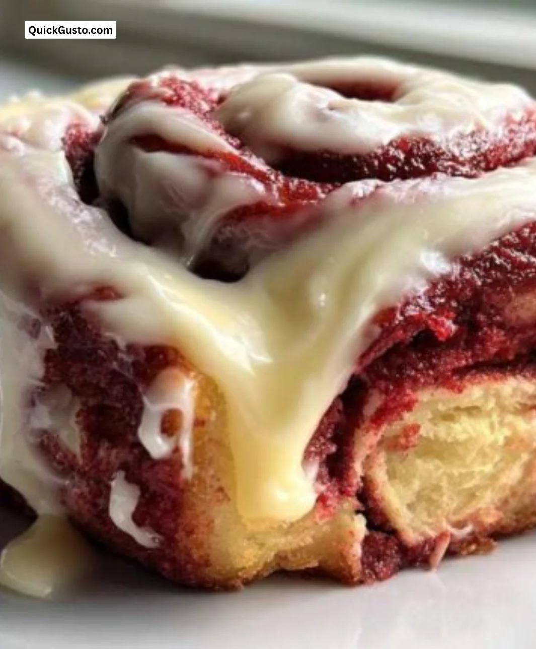 Decadent Red Velvet Cinnamon Rolls topped with cream cheese frosting.