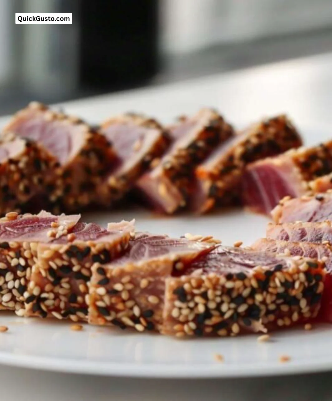 Plate of seared Ahi Tuna garnished with vegetables and sauce.