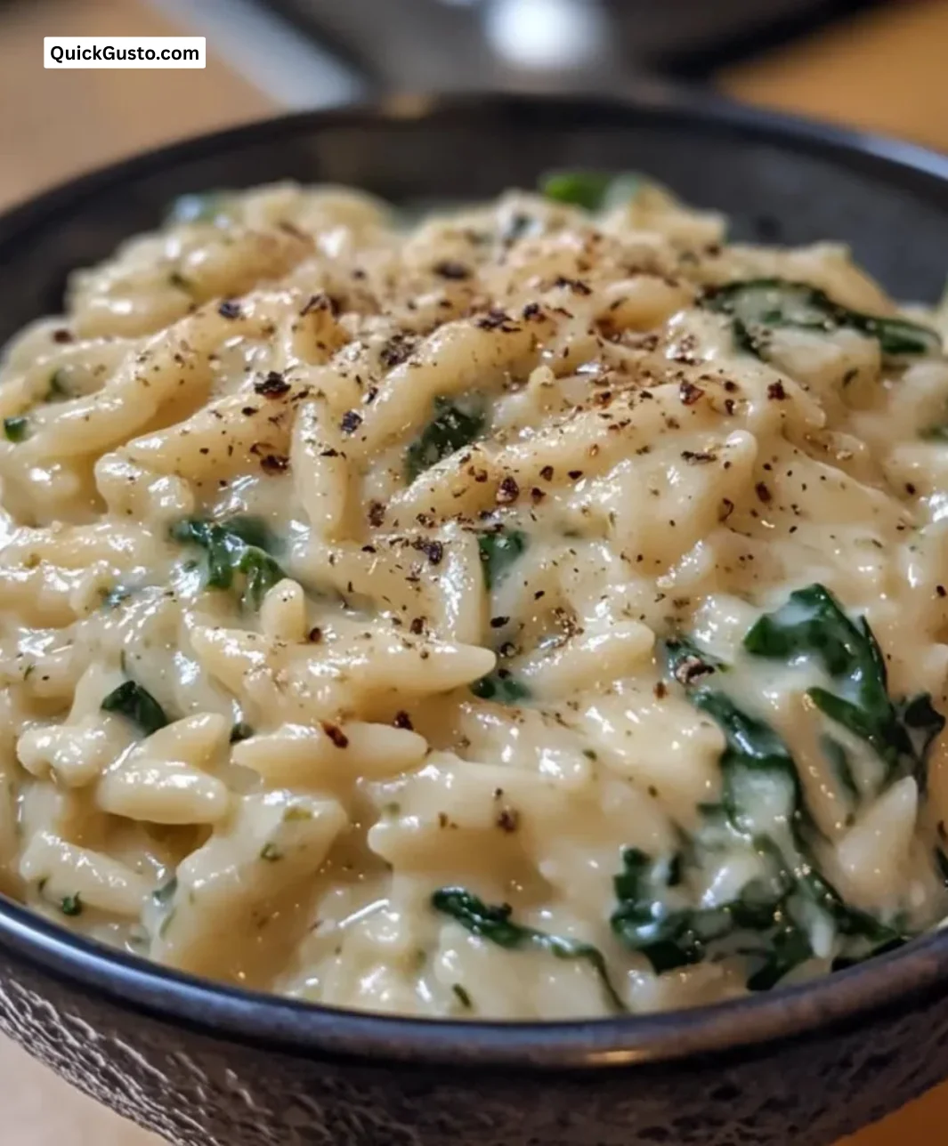 Creamy Spinach Ricotta Orzo in a bowl garnished with fresh herbs