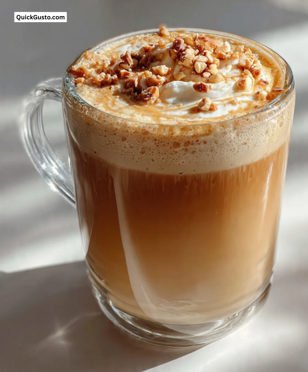 A steaming cup of Toffee Nut Coffee topped with whipped cream and toffee bits