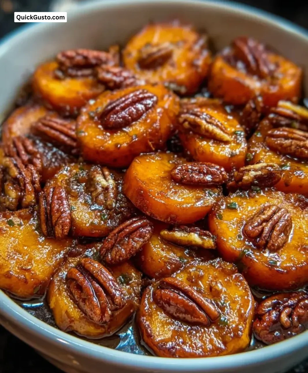 Delicious candied yams topped with toasted pecans in a serving dish