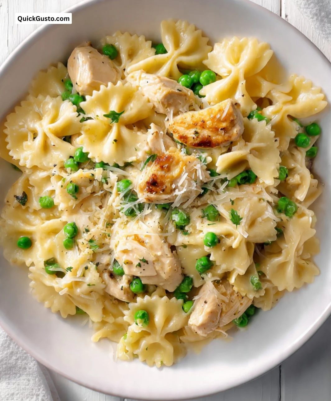 Creamy pasta dish featuring chicken, peas, and melted cheese.