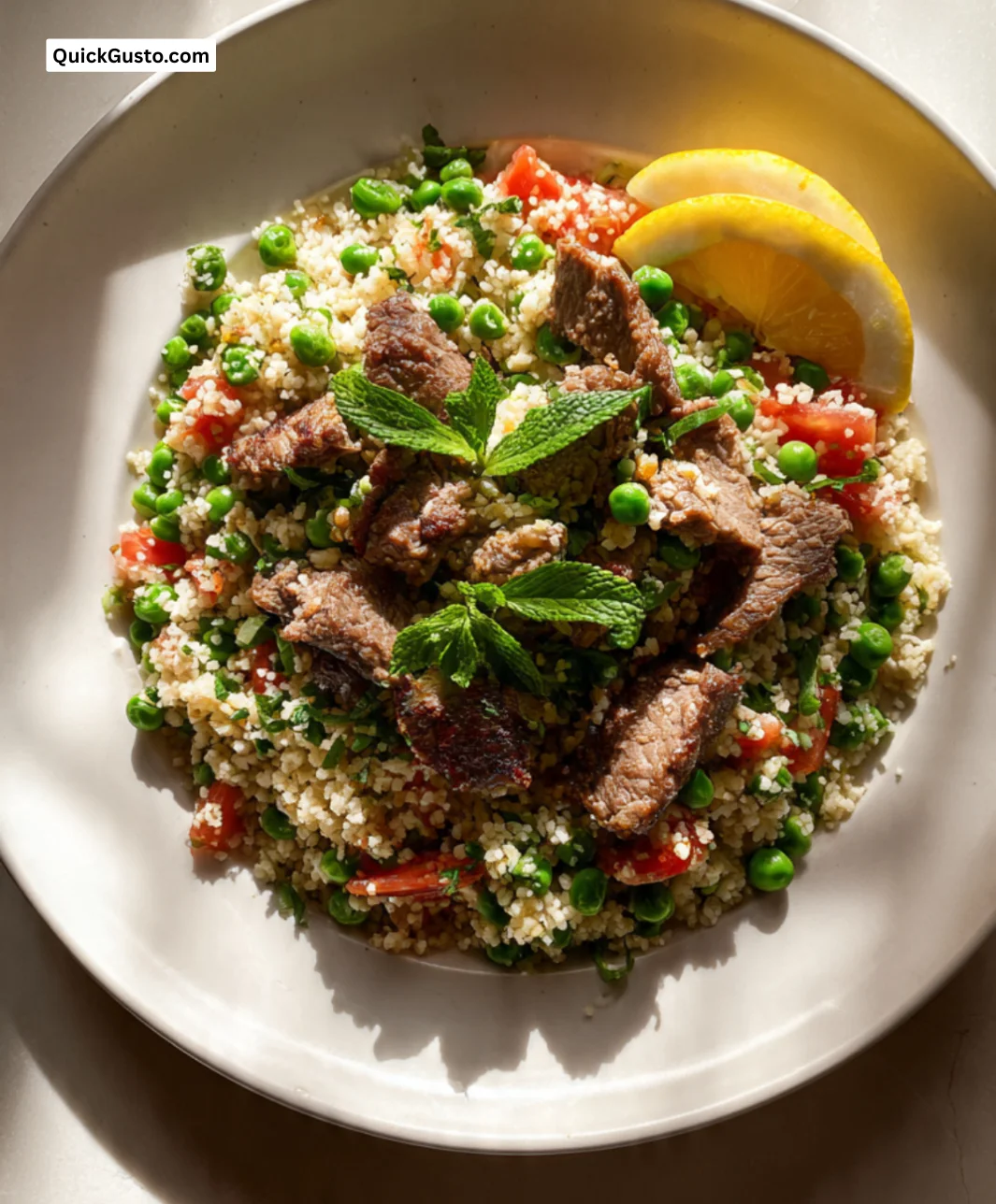 Plate of crispy lamb and pea tabbouleh garnished with fresh herbs