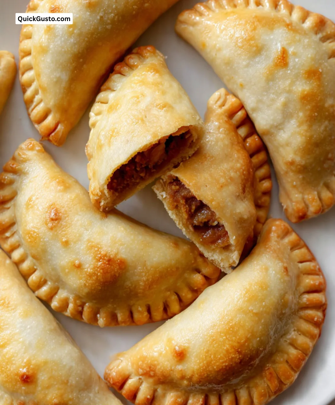 Homemade empanadas with flaky crust and delicious filling on a wooden board.
