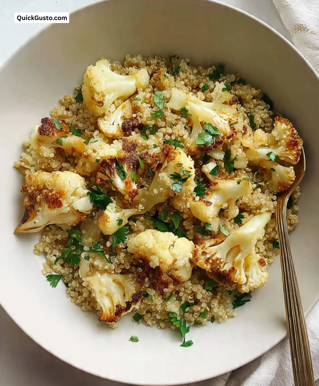 Fennel-roasted cauliflower dish served with quinoa and fresh herbs.