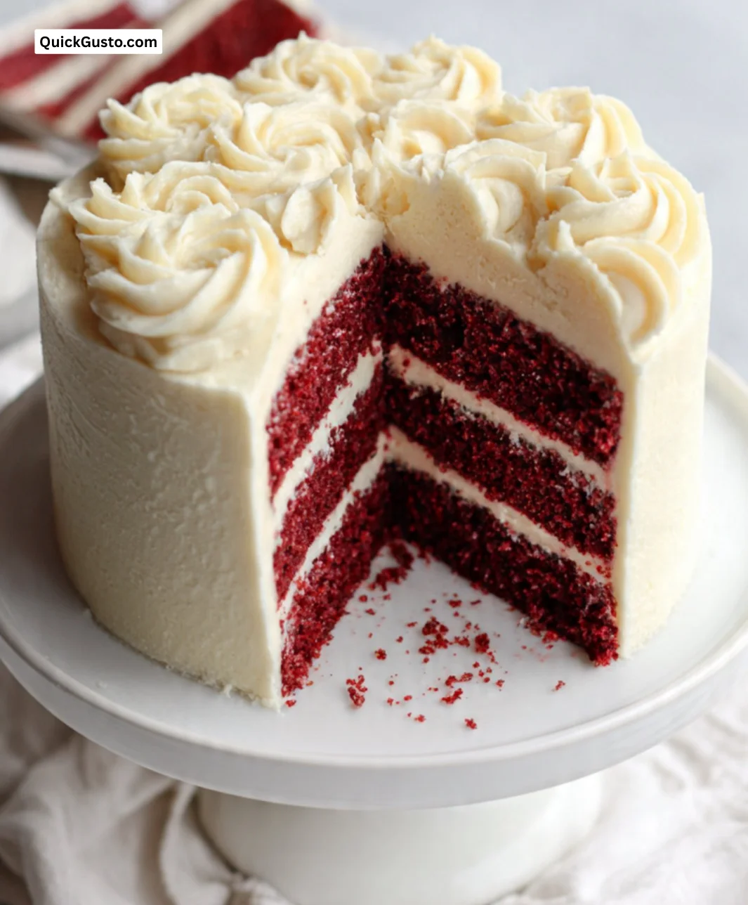 A slice of gluten-free red velvet cake topped with cream cheese frosting.
