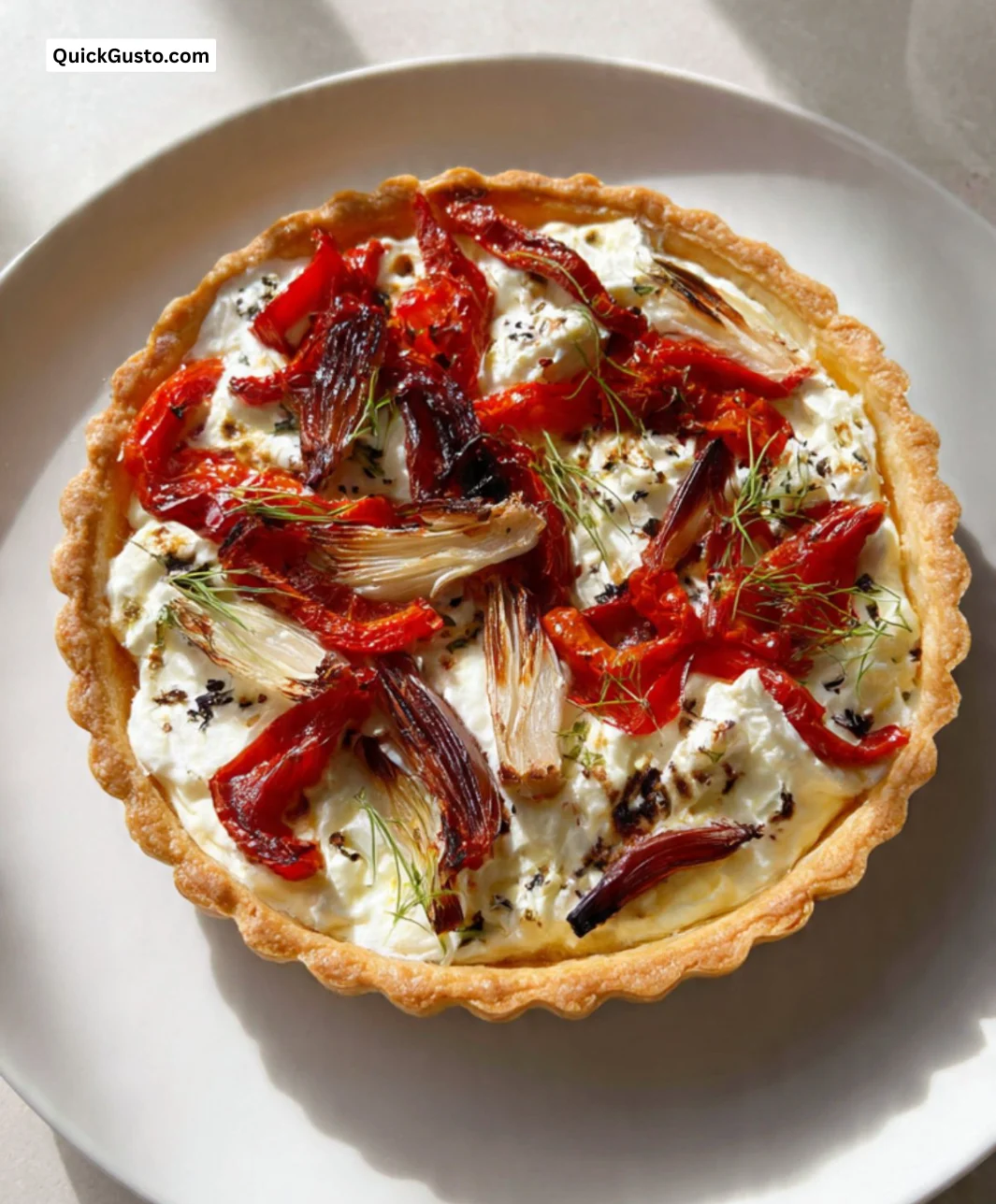 Goat's cheese tart with fennel and roasted red peppers on a plate
