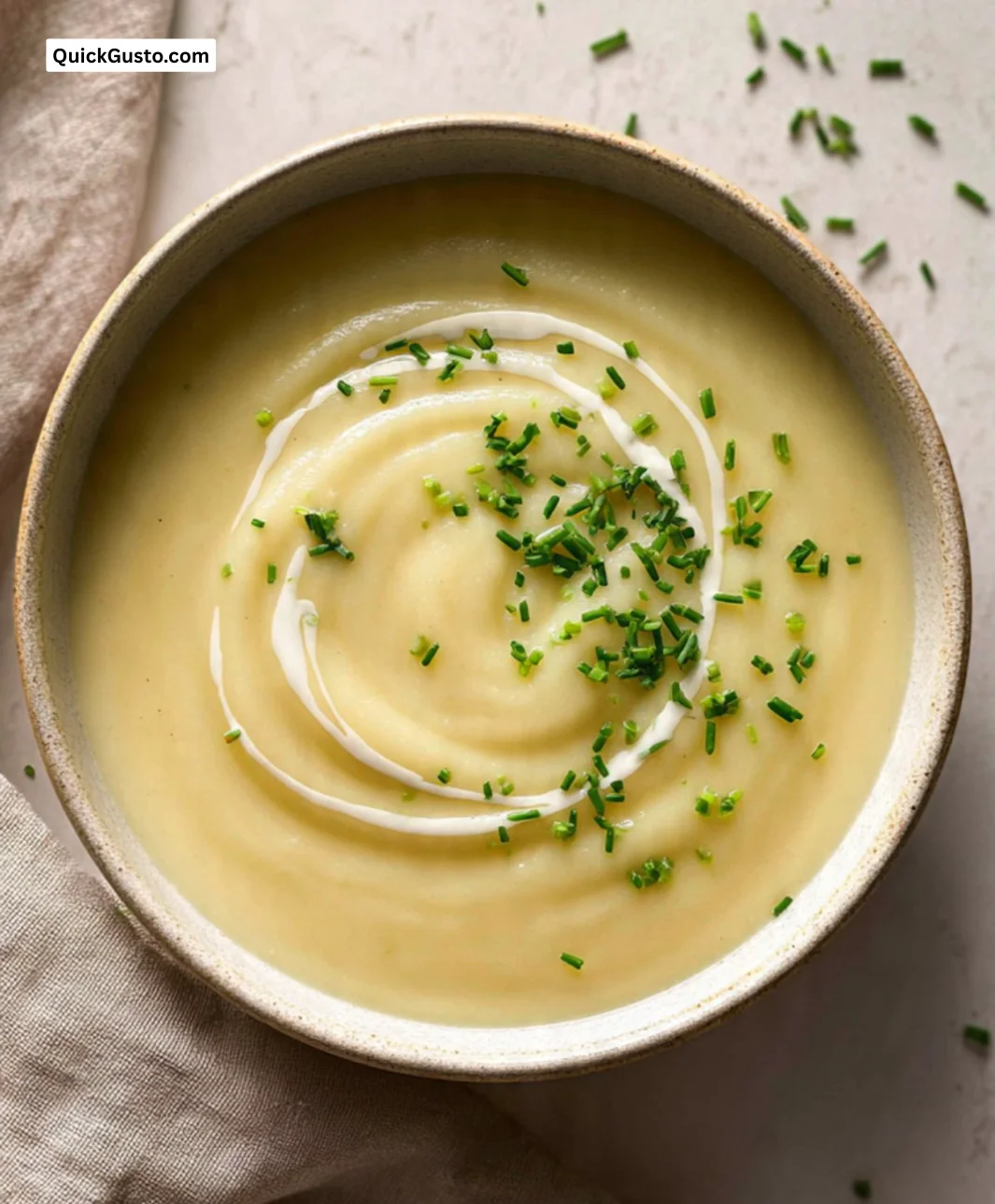 Bowl of creamy mashed potato soup garnished with chives