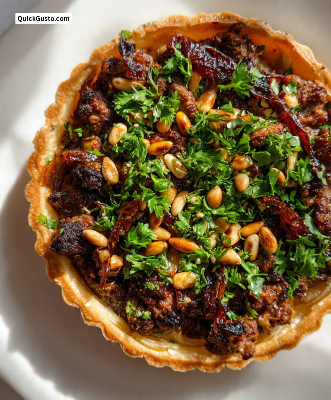 Middle Eastern lamb tart with spices and herbs served on a plate.