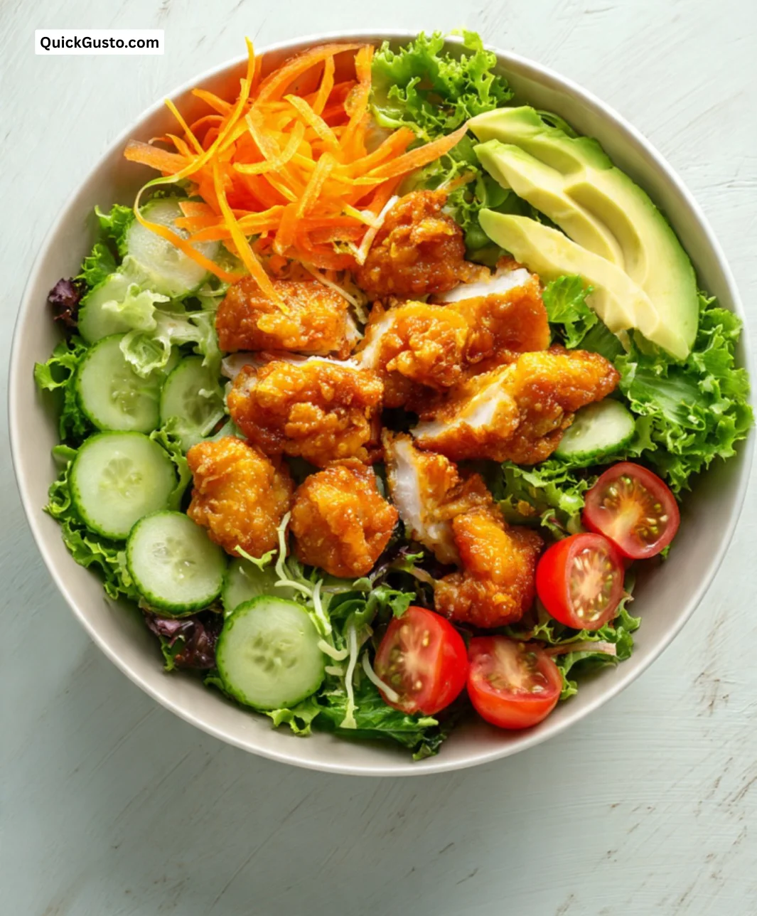 Salad bowl with butter fried chicken, fresh greens, and colorful toppings.