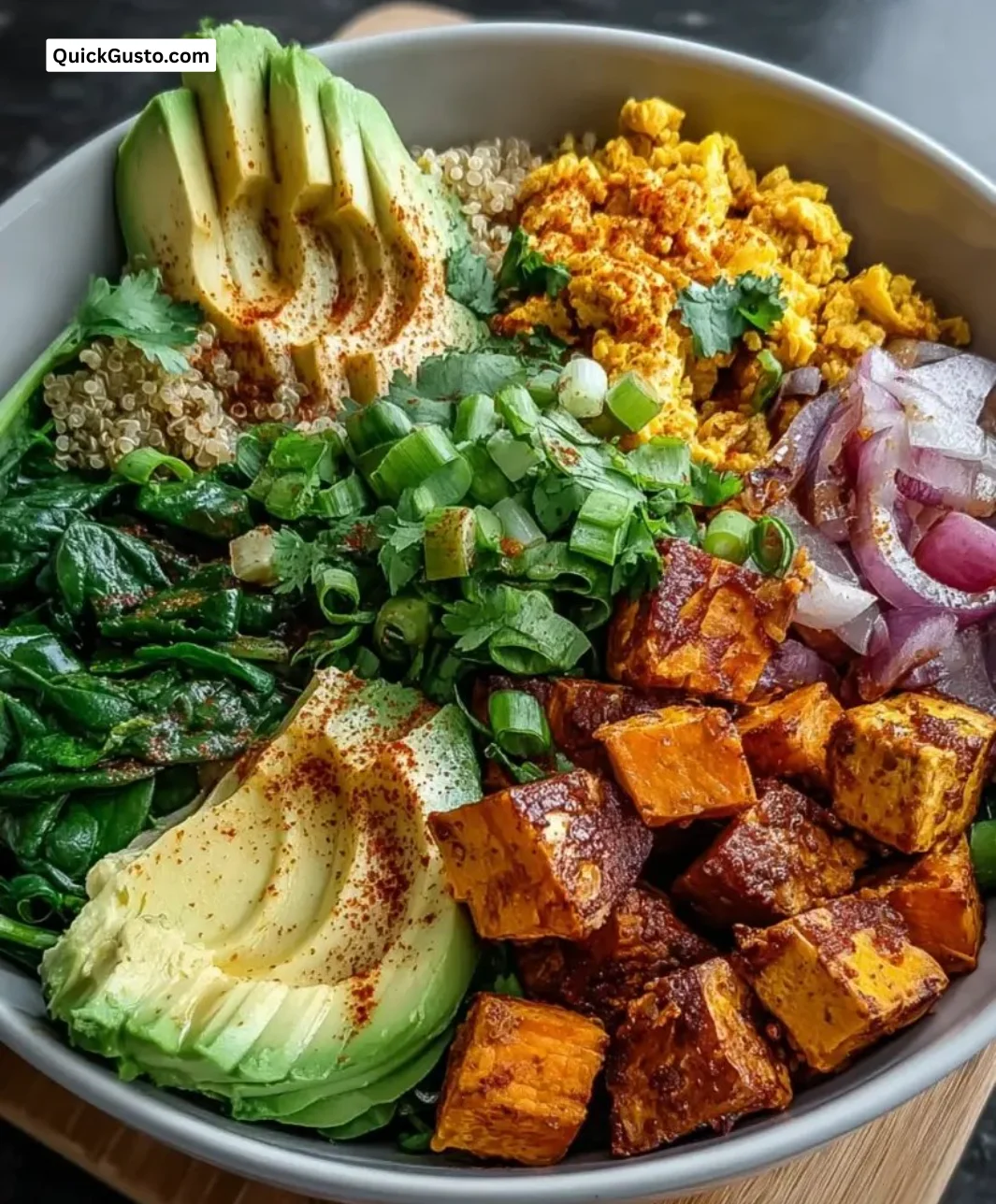 Tofu scramble vegan breakfast bowl topped with fresh vegetables