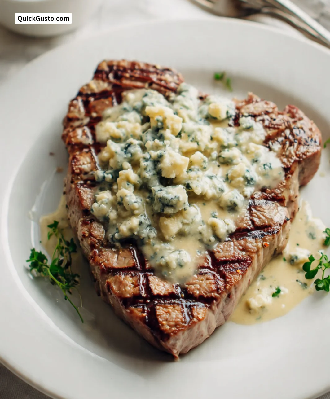 Veal steak topped with Danablu sauce on a plate