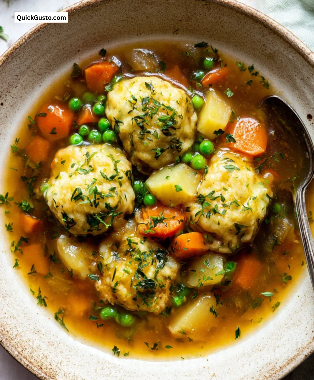 Bowl of Vegetable Stew topped with Herby Dumplings, packed with fresh vegetables.
