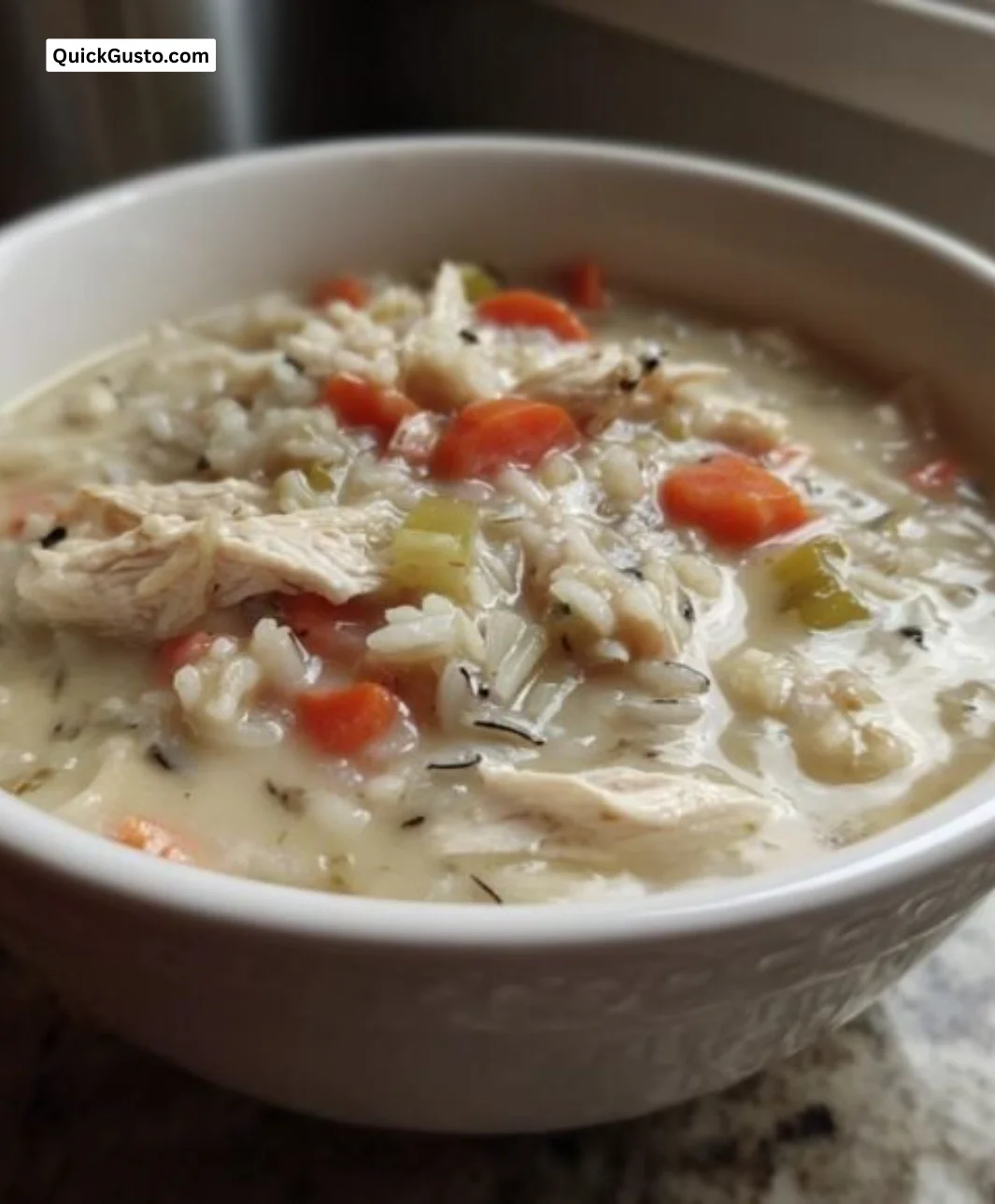 Bowl of delicious wild rice soup garnished with herbs and vegetables.
