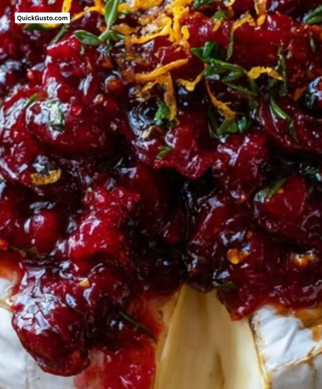Baked brie topped with cranberry sauce, served warm and gooey on a platter.