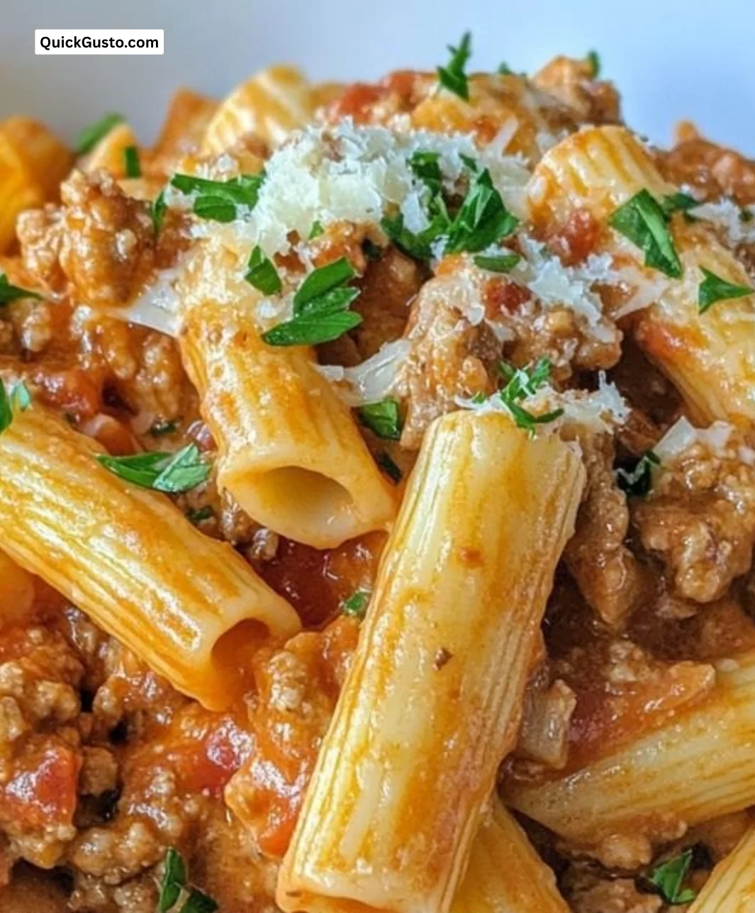 Cheesy ground turkey pasta served in a bowl garnished with parsley.