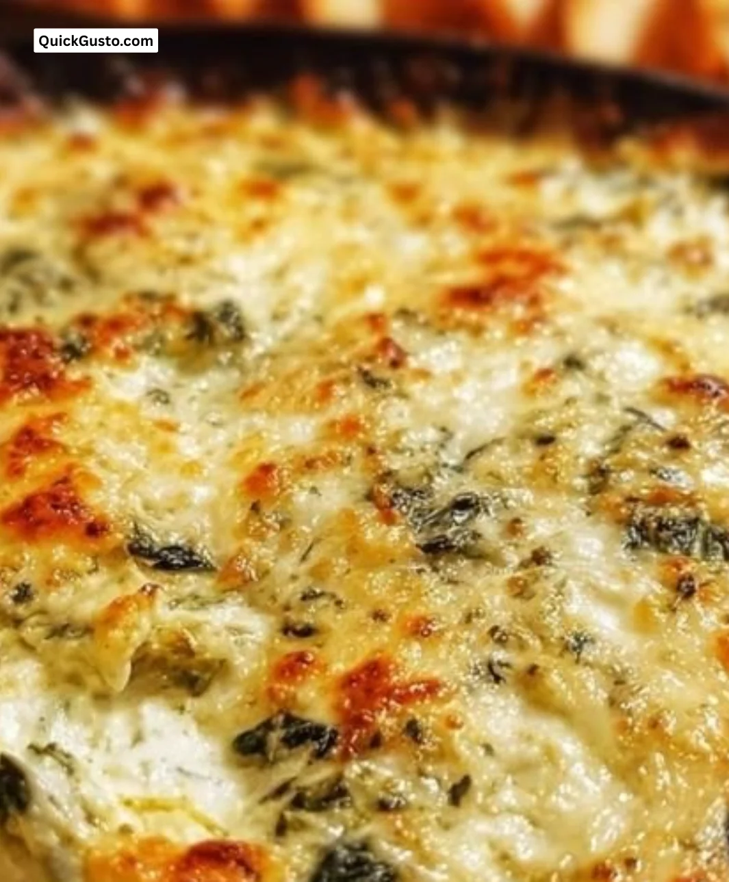 Bowl of cheesy spinach artichoke dip served with tortilla chips