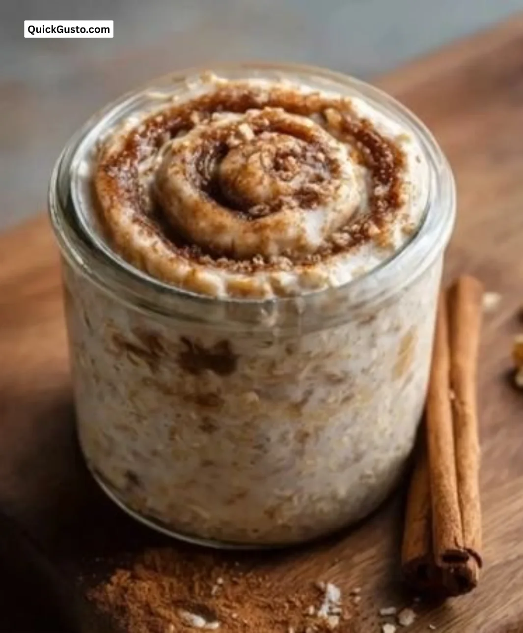 Bowl of cinnamon roll overnight oats topped with cinnamon and nuts