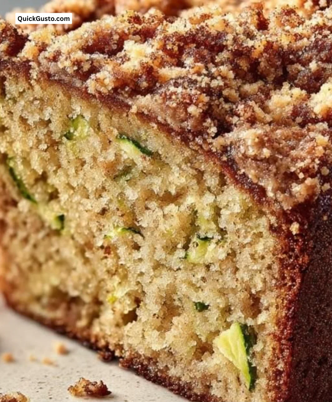 Cinnamon streusel topped zucchini bread sliced on a wooden board
