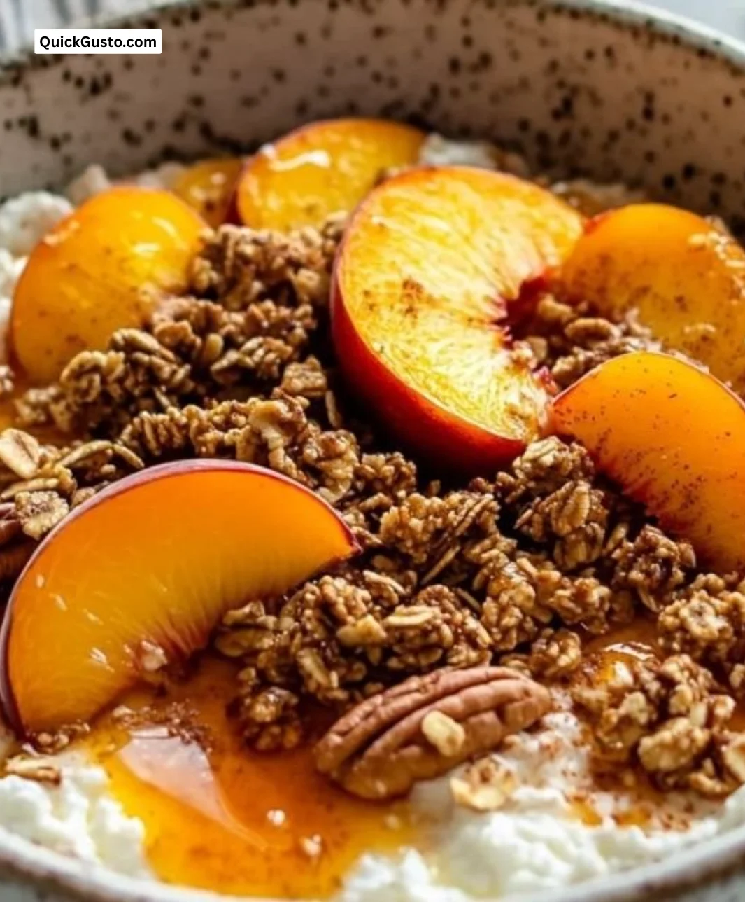 Cottage cheese peach cobbler bowl topped with fresh peaches and a sprinkle of cinnamon.
