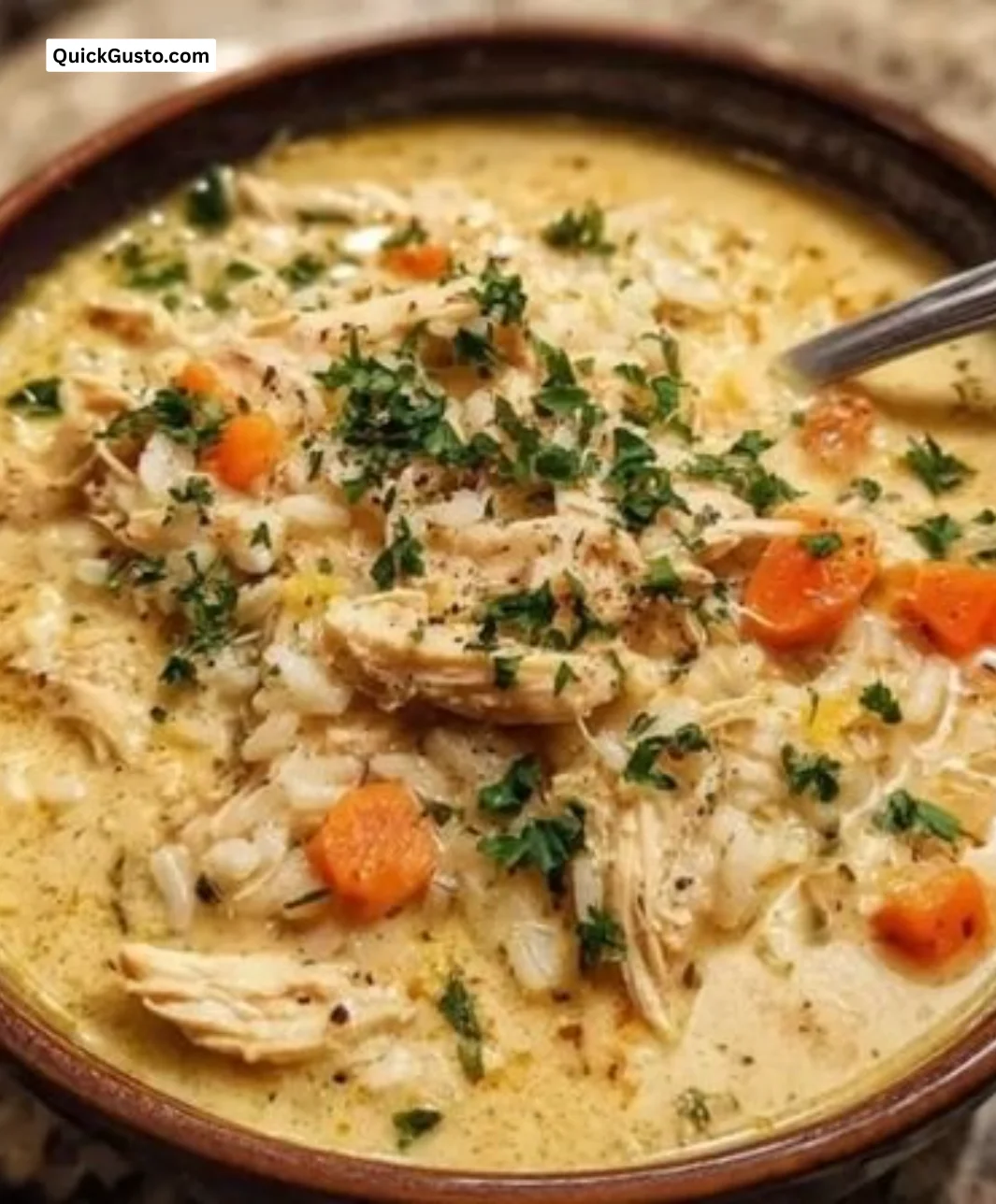 Bowl of creamy chicken and rice soup with fresh herbs and vegetables