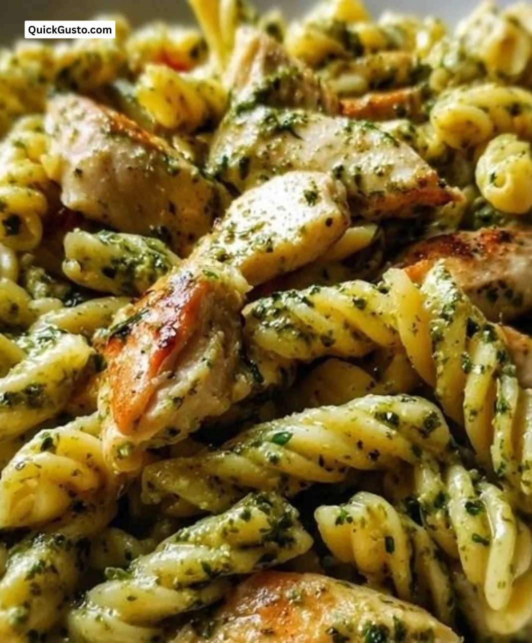 Creamy pesto chicken pasta garnished with basil and parmesan cheese