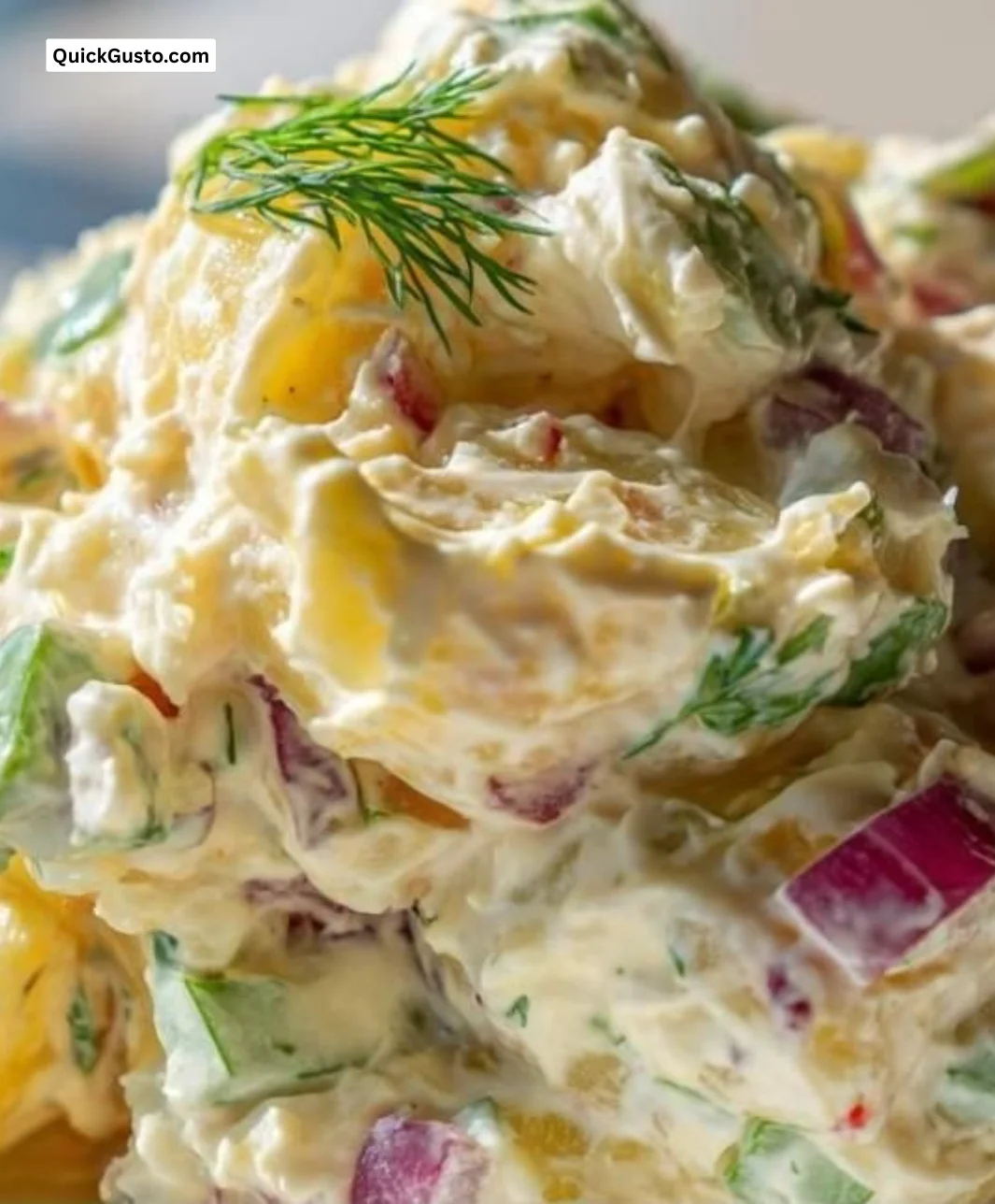Delicious creamy potato salad served in a bowl with fresh herbs.