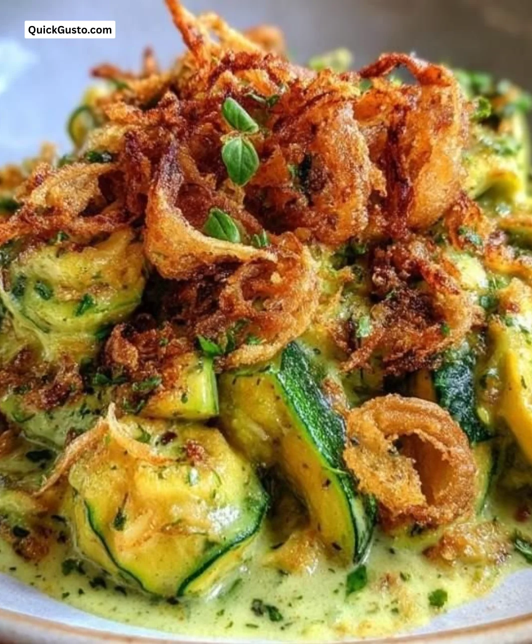 Creamy zucchini and yellow squash with crispy onion topping served in a dish.