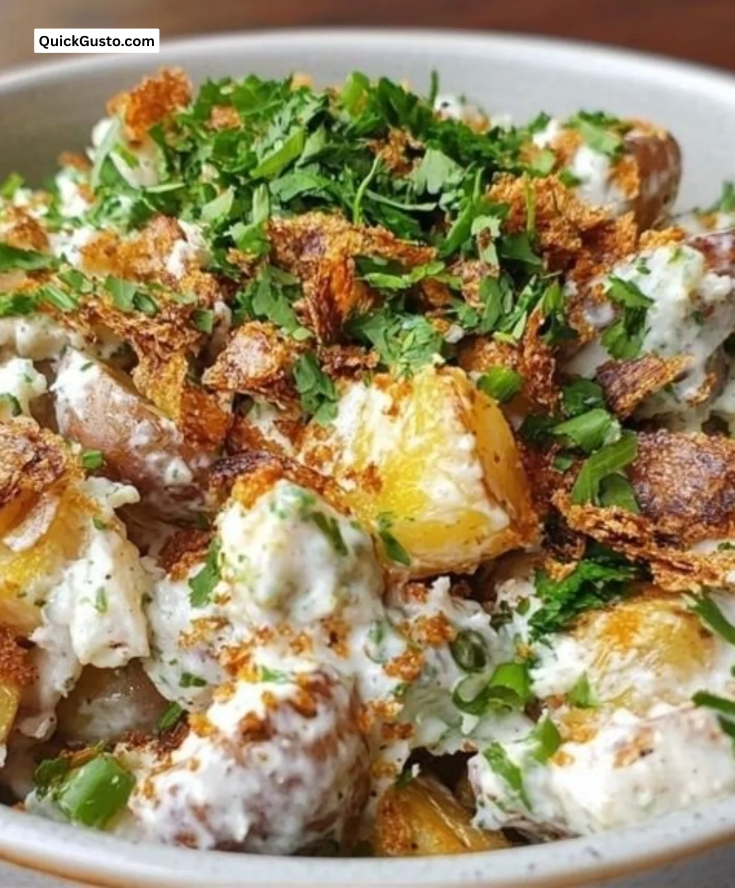 Crispy smashed potato salad served in a bowl with herbs and spices