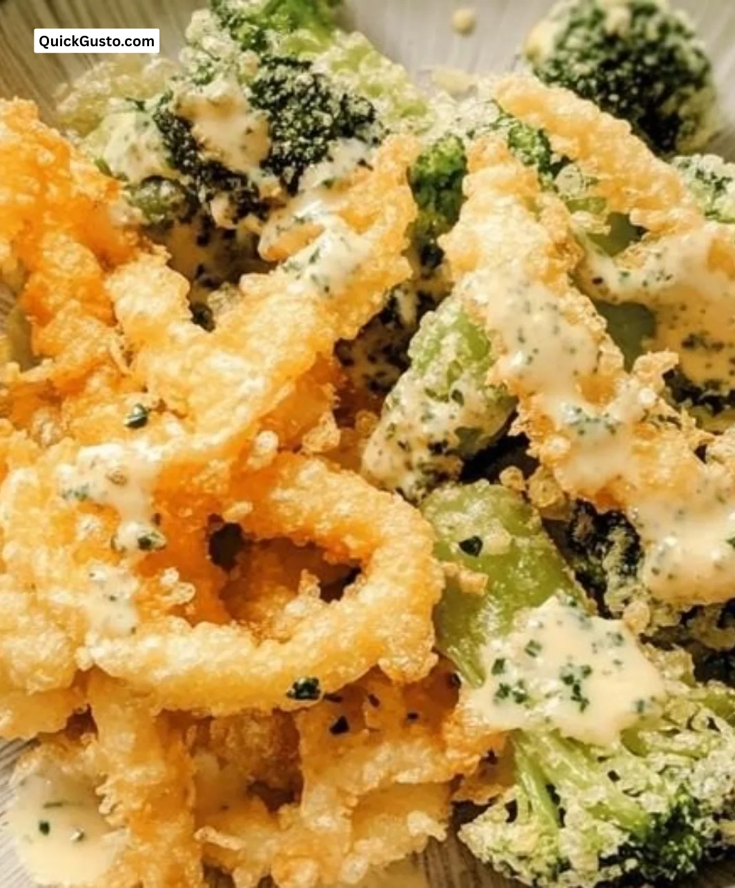 Crispy veggie tempura served on a plate with dipping sauce.