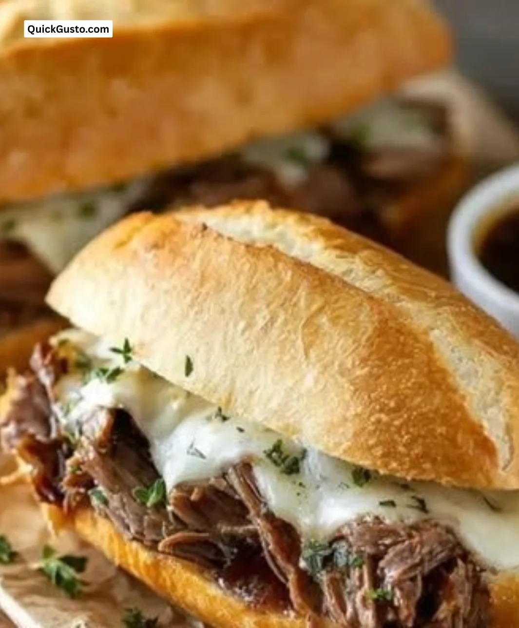 Crock Pot French Dip Sandwiches served with dipping sauce and garnished.