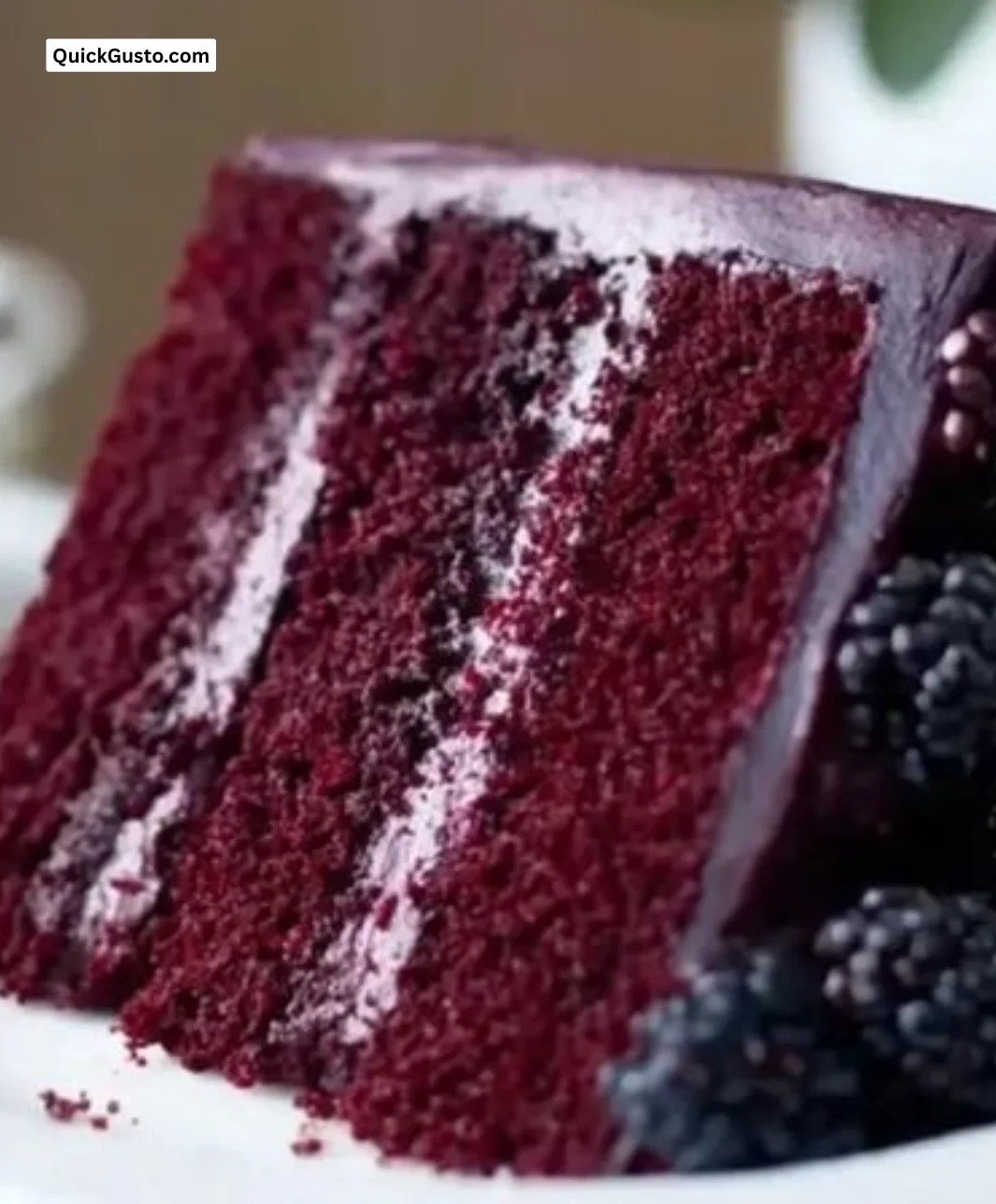 Decadent blackberry velvet cake topped with fresh blackberries and cream