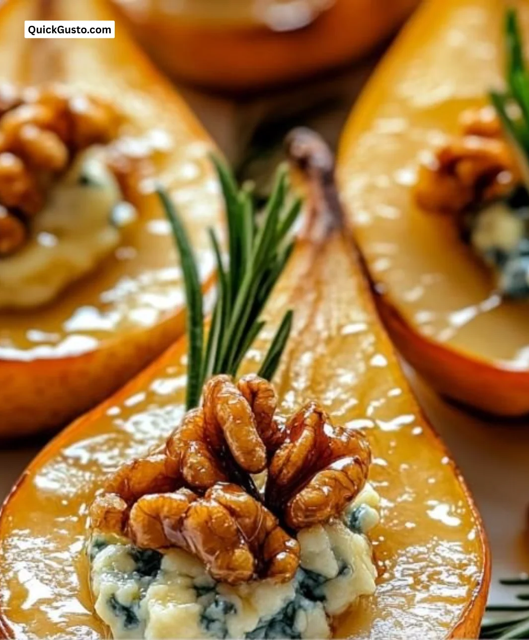 Elegant blue cheese stuffed pears garnished with herbs on a white plate.