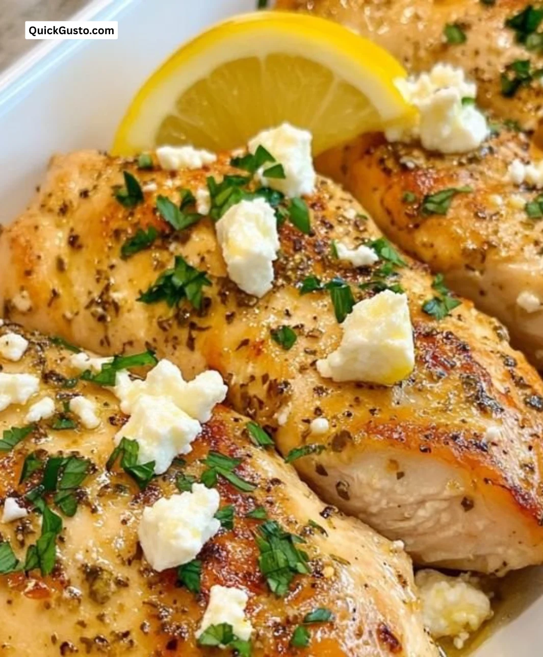 Plate of Greek Chicken with Lemon and Feta garnished with herbs
