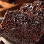 Sliced healthy double chocolate zucchini bread on a wooden cutting board