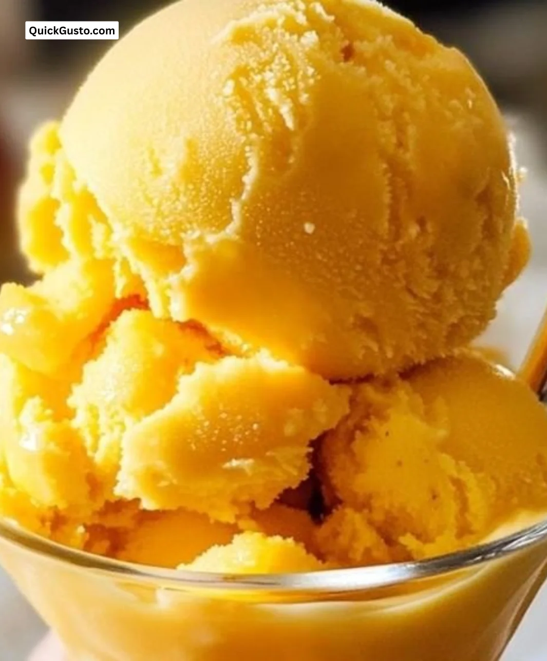 Bowl of homemade instant mango sorbet topped with fresh mango slices