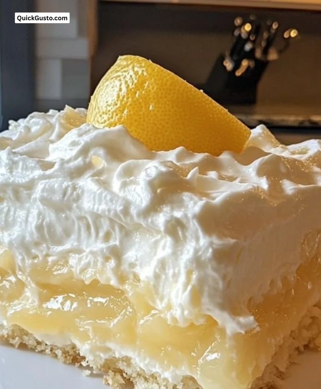 Slice of Lemon Dream Cake topped with lemon zest and cream icing