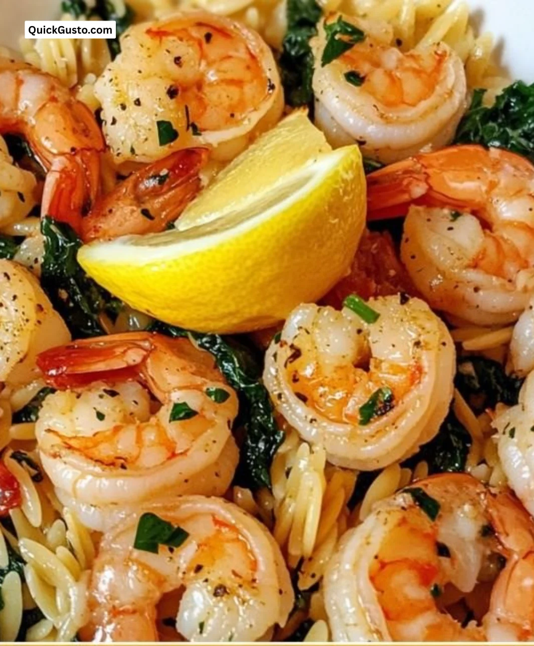 Lemon Garlic Shrimp with Spinach Orzo served in a bowl garnished with herbs.