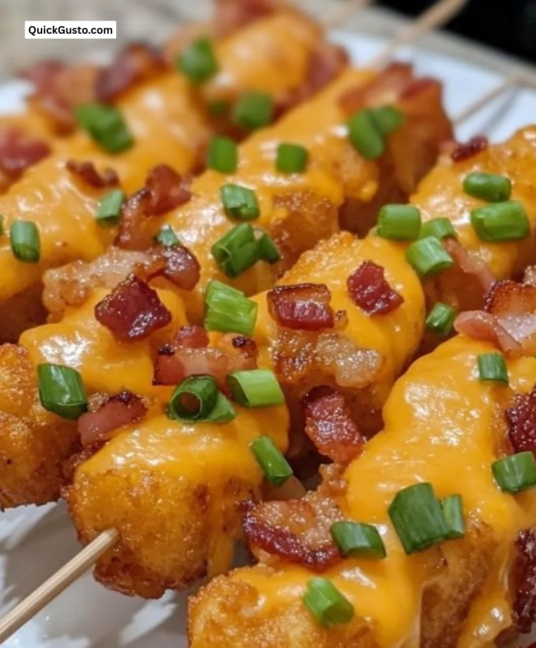 Loaded tater tot skewers with cheese, bacon, and toppings on a grill
