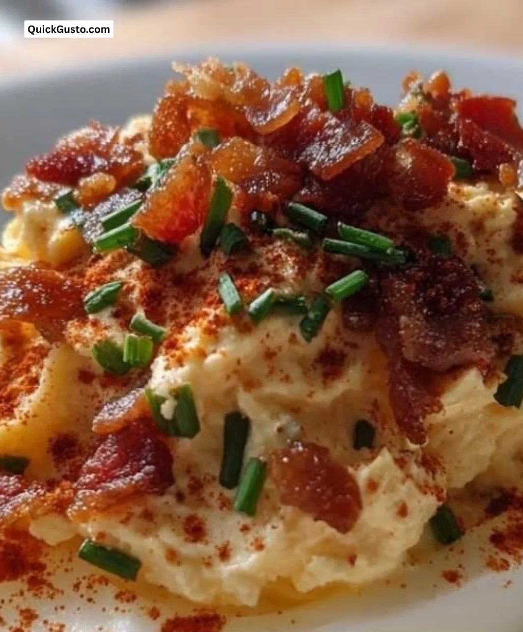 Plate of Million Dollar Bacon Deviled Eggs garnished with herbs