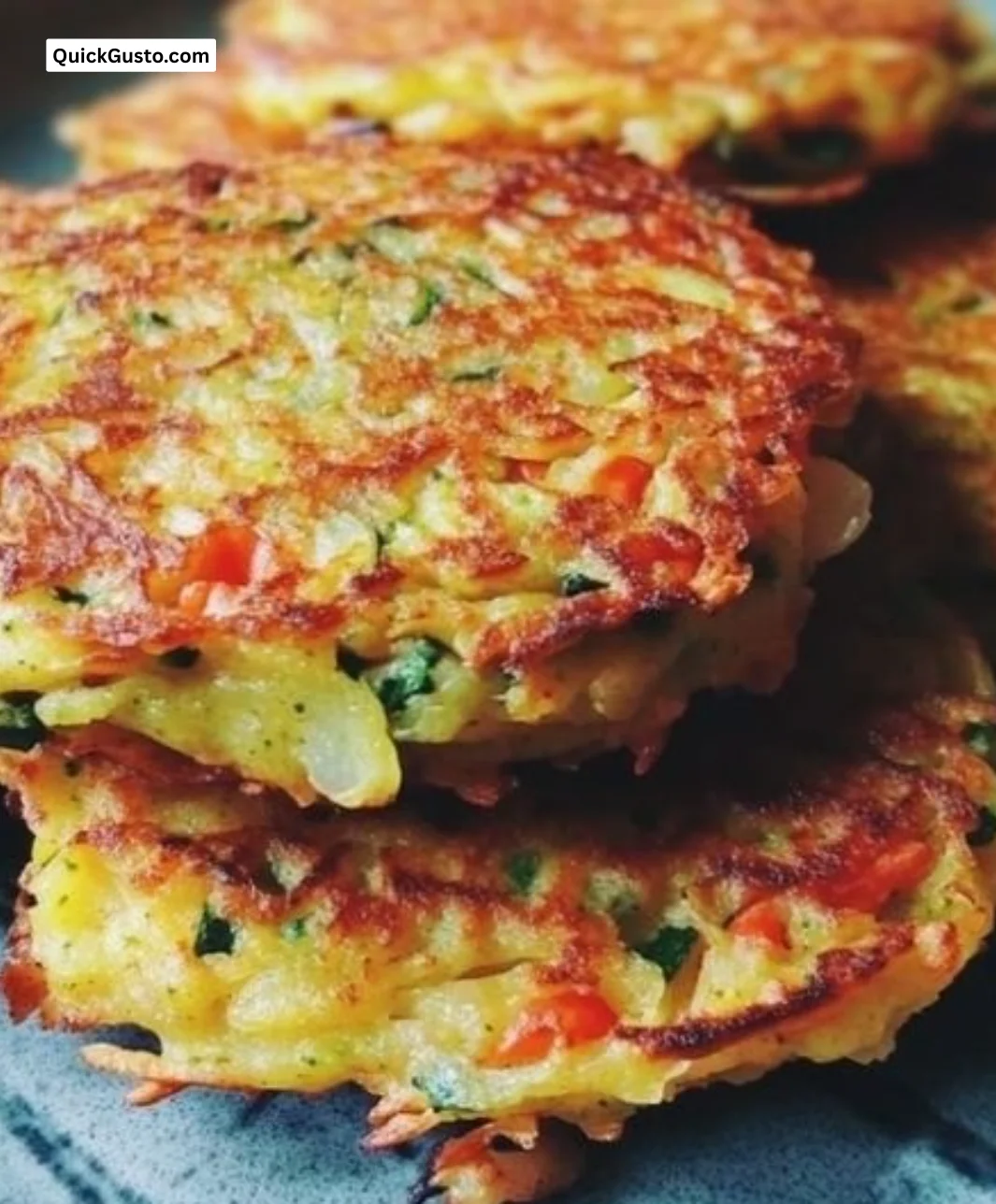 Plate of mini veggie pancakes topped with fresh herbs and veggies